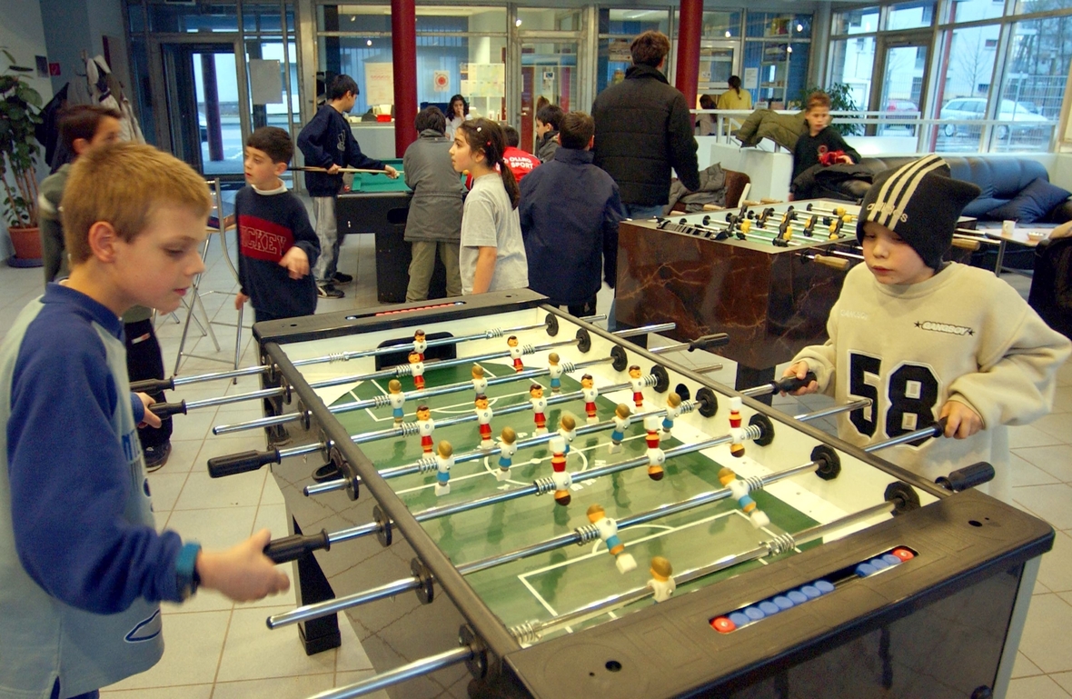 Kinder und Jugendliche spielen in einem Jugendzentrum in Köln Tischfussball. 