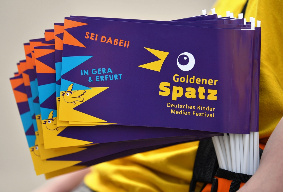 Jedes Jahr findet das Deutsche Kinder Medien Festival in Gera und Erfurt statt. Die besten Angebote gewinnen den "Goldenen Spatz". Hier sieht man kleine bunte Fähnchen mit dem Schriftzug des Festivals. 