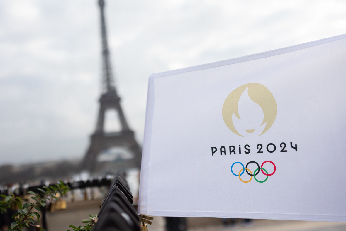 Flagge der Olympischen Spielen 2024 in Paris vor dem Pariser Eiffelturm.